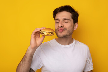 Hungry Excited Guy Eating Tasty Burger At Studio