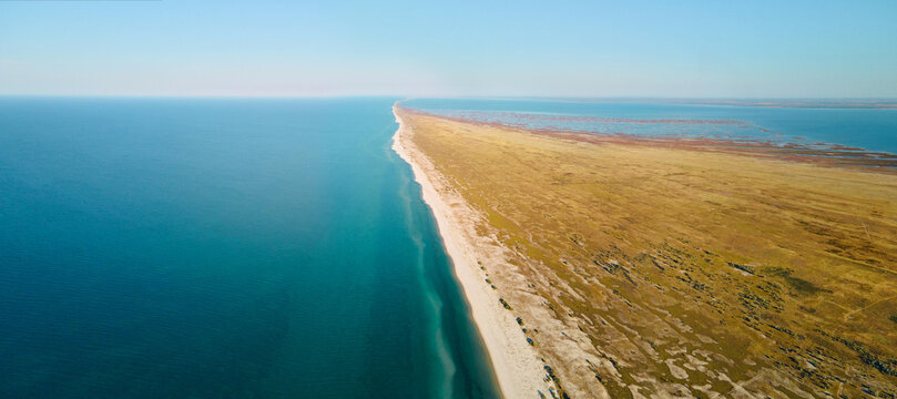 Panoramic view of sandy beach and clear blue sea water. Banner image seascape from air. Dzharylhach island, Ukraine