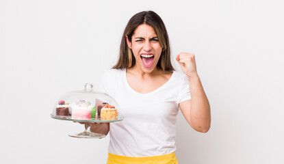 pretty hispanic woman shouting aggressively with an angry expression. home made cakes concept