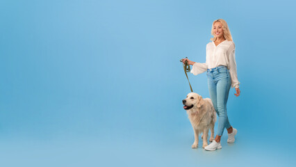 Young woman walking with her dog on a leash