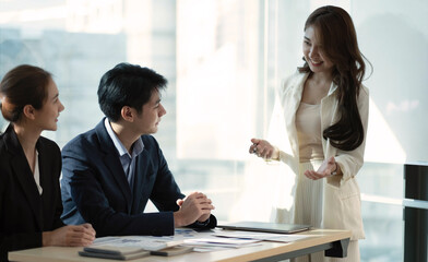 Beautiful business people are using gadgets, talking and smiling during the conference in office