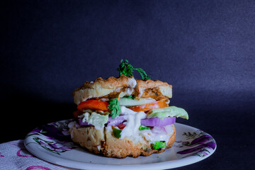Delicious Burger with green fresh vegetable and mayonnaise and cheese.