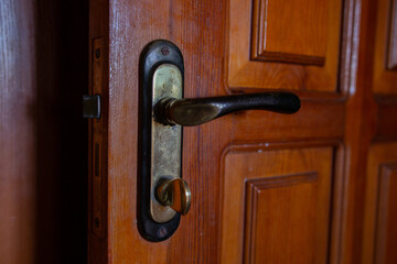 Obraz premium old handle with a lock on a wooden door