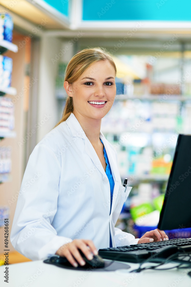 Poster Let me bring up your details on the computer. Shot of a young pharmacist using a computer at the checkout counter.