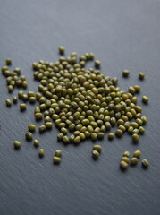 Green Lenteja, classic spanish variety of  lentil (Lens culinaris or Lens esculenta),  edible legume, lens-shaped seeds on grey stone background