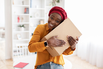 Positive african american woman got her delivery, embracing box