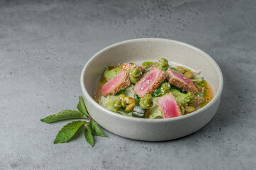 tuna salad with edamame beans and ponzu sauce on gray background