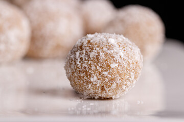 Beautiful sweets with coconut on a white plate on a black background