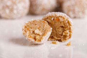 Beautiful sweets with coconut on a white plate on a black background
