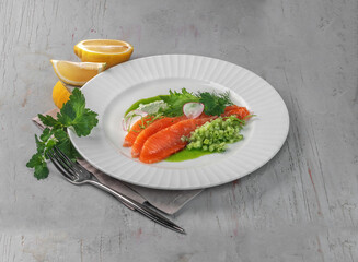 snack with salmon fish, soft cheese and cucumber salad on gray background