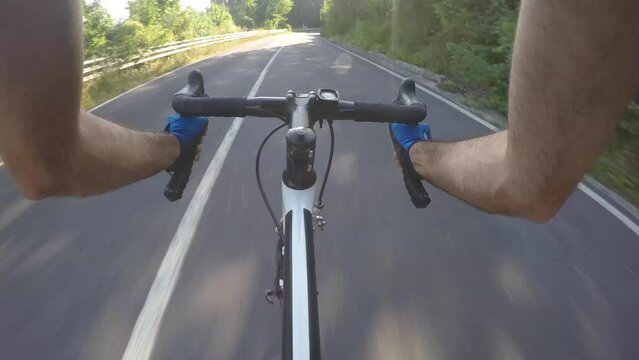 Man cycling downhill and descending on a countryside road
