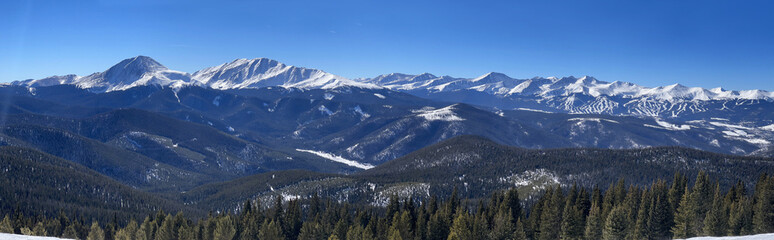 Beautiful panoramic photo of winter landscape. Mountains covered with snow over clean blue sky on a...