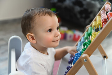 The kid is learning to count. Portrait of a child with abacus to study mathematics. One and a half year old baby