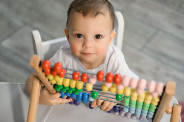 The kid is learning to count. Portrait of a child with abacus to study mathematics. One and a half year old baby