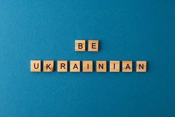 Be Ukrainian background. Phrase from wooden letters. Top view words. The phrases is laid out in wood letter. Motivation.