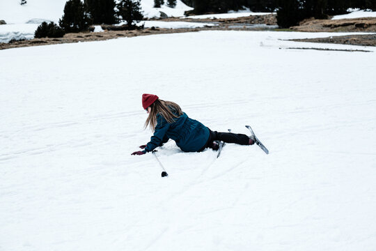 Female skier during fall on snowy ground