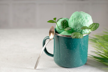 Organic ice cream with fresh green mint in a metal mug on a light background. Healthy natural food. copy space