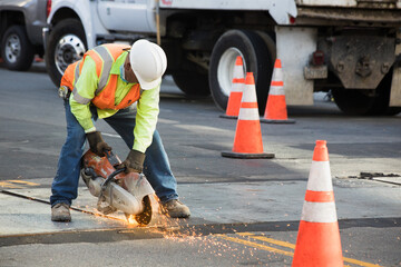 A construction worker with reflective vests and helmet performing urban road maintenance