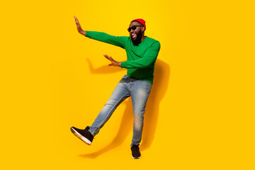 Photo of glad funny nice man dance enjoy discotheque wear sunglass red beanie green shirt isolated yellow color background