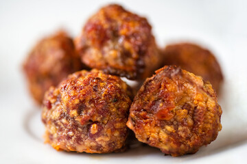 Baked miced meat with cheese, pile on white plate.