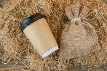 disposable coffee cup of coffee on straw background
