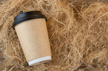 disposable coffee cup of coffee on straw background