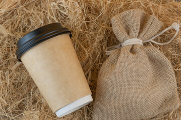 disposable coffee cup of coffee on straw background
