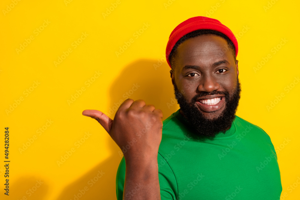 Poster portrait of attractive cheerful guy demonstrating copy empty blank space ad isolated over bright yel