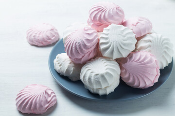 pink and white marshmallows. dessert zephyr with cup of tea on the table. Meringue dessert with green mint in a grew plate on the white background. traditional Russian sweet dessert. copy space