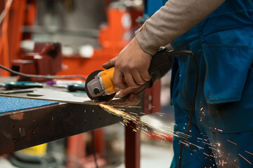 Technician worker cutting metal with many sharp sparks. Using equipments to cat iron