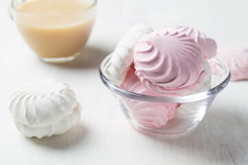 Pink and white Marshmallow dessert zephyr on the table. Meringue dessert with cup of tea in a glass bowl on the white background. traditional Russian sweet dessert. copy space.