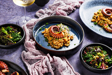 A portion of risotto with octopus tentacles. purple background. Top view