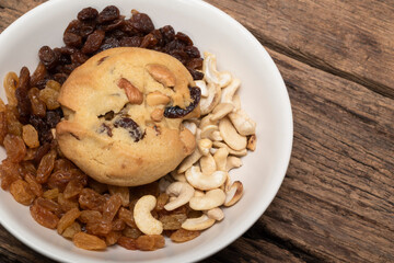 Cashew nuts raisin cookies in plate on wood table.