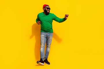 Fototapeta na wymiar Photo of crazy cheerful dancer man have weekend fun wear sunglass red beanie green shirt isolated yellow color background