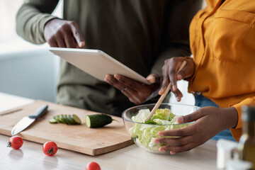Black Couple Checking Recipe In Digital Tablet While Cooking Together In Kitchen