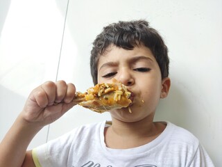 Menino comendo coxa de frango 