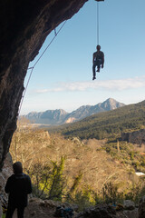 the climber hangs on a rope in a cave