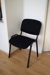 Black chair in the corner of the office