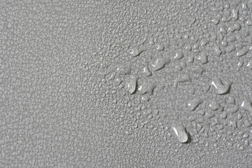 Gray water-repellent fabric for furniture or clothing, with moisture drops. Artificial surface....