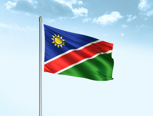 Fototapeta na wymiar Namibia national flag waving in blue sky with clouds. Namibia flag. 3D illustration