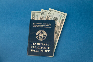 Belarusian passport with dollars on a blue background. Travel, vacation and emigration concept.