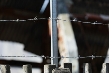 Betonowe ogrodzenie z drutu kolczastego w około obozu imigrantów.