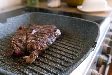 Juicy beef meat steak cooking on griddle pan at professional kitchen. Prime steak frying at grill. Delicious, modern cuisine.