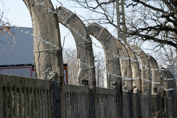 Betonowe ogrodzenie z drutu kolczastego w około obozu imigrantów.