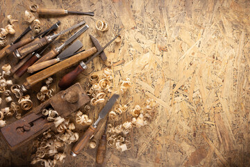 Plane jointer carpenter or joiner tool and wood shavings. Woodworking tools at wooden table