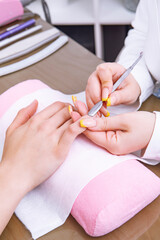 Manicurist preparing client's fingernail cuticles in salon. High quality photo