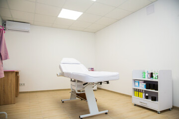 Empty white sugaring table, chair, in spa salon ready for a next client