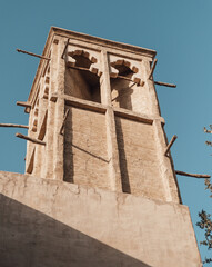 Low angle view of antique stylized clay arabic tower. Al Seef district architecture elements. 