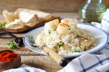 Italian cuisine. Plate of scallop risotto, olive oil and parmesan cheese