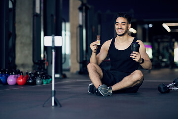 Fototapeta na wymiar Handsome Arab Male Athlete Advertsing Fitness Snacks In His Video Blog